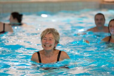 Mehrere Kursteilnehmer machen Übungen im Wasser.
