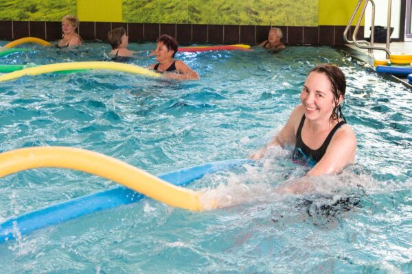 Die Kursteilnehmer machen jeweils zu zweit Übungen mit Poolnudeln.